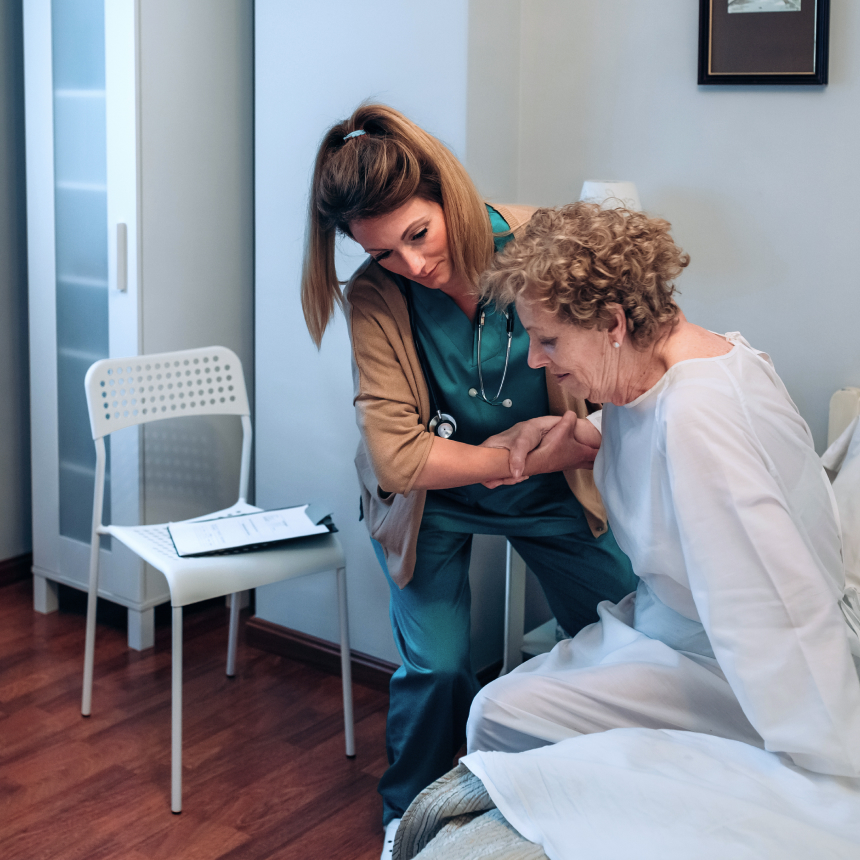 Pflegeperson hilft älteren Patienten aus dem Bett zu bekommen – Stockfoto